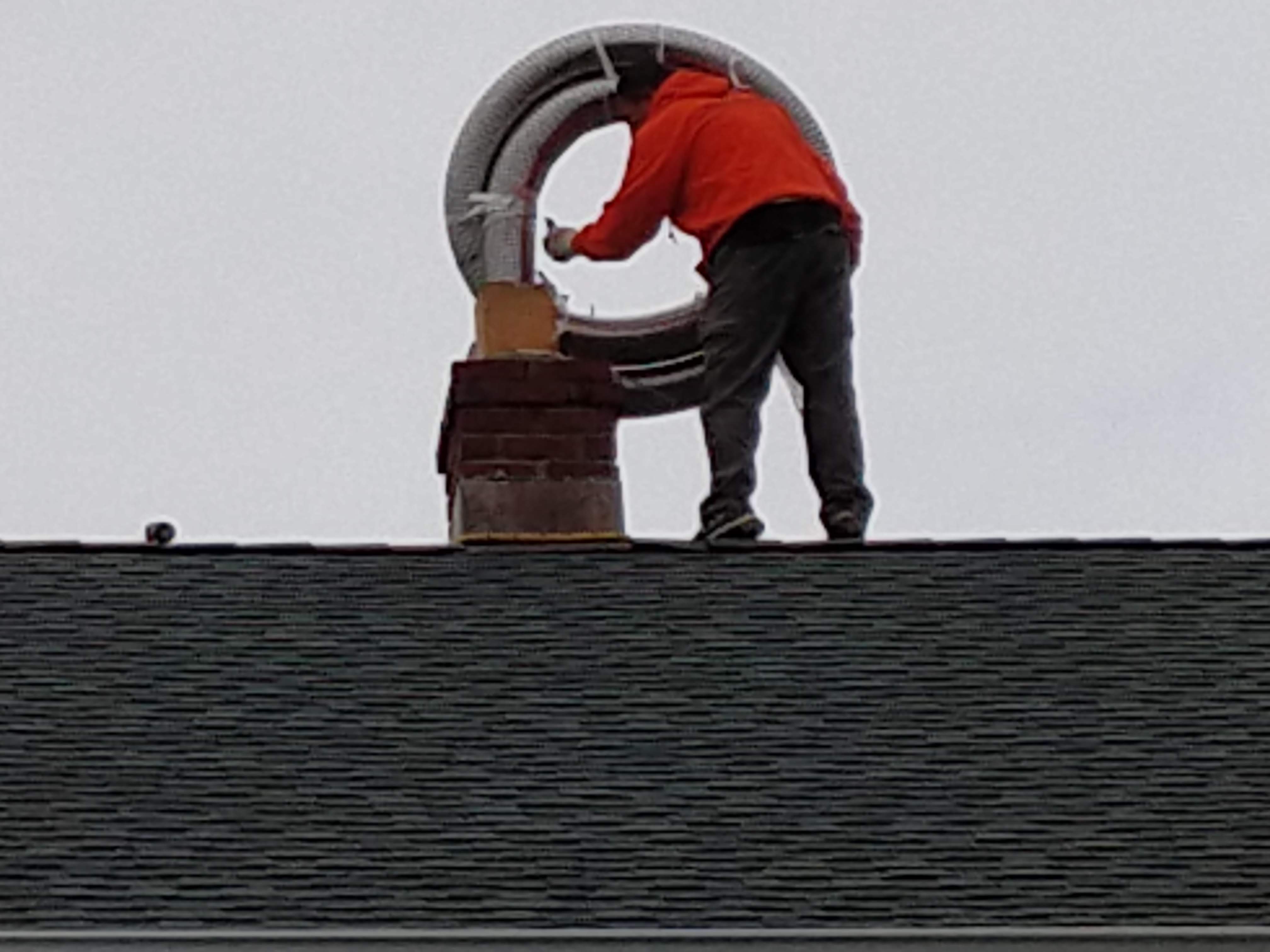 Flexible stainless chimney liner being installed in East Islip, New York